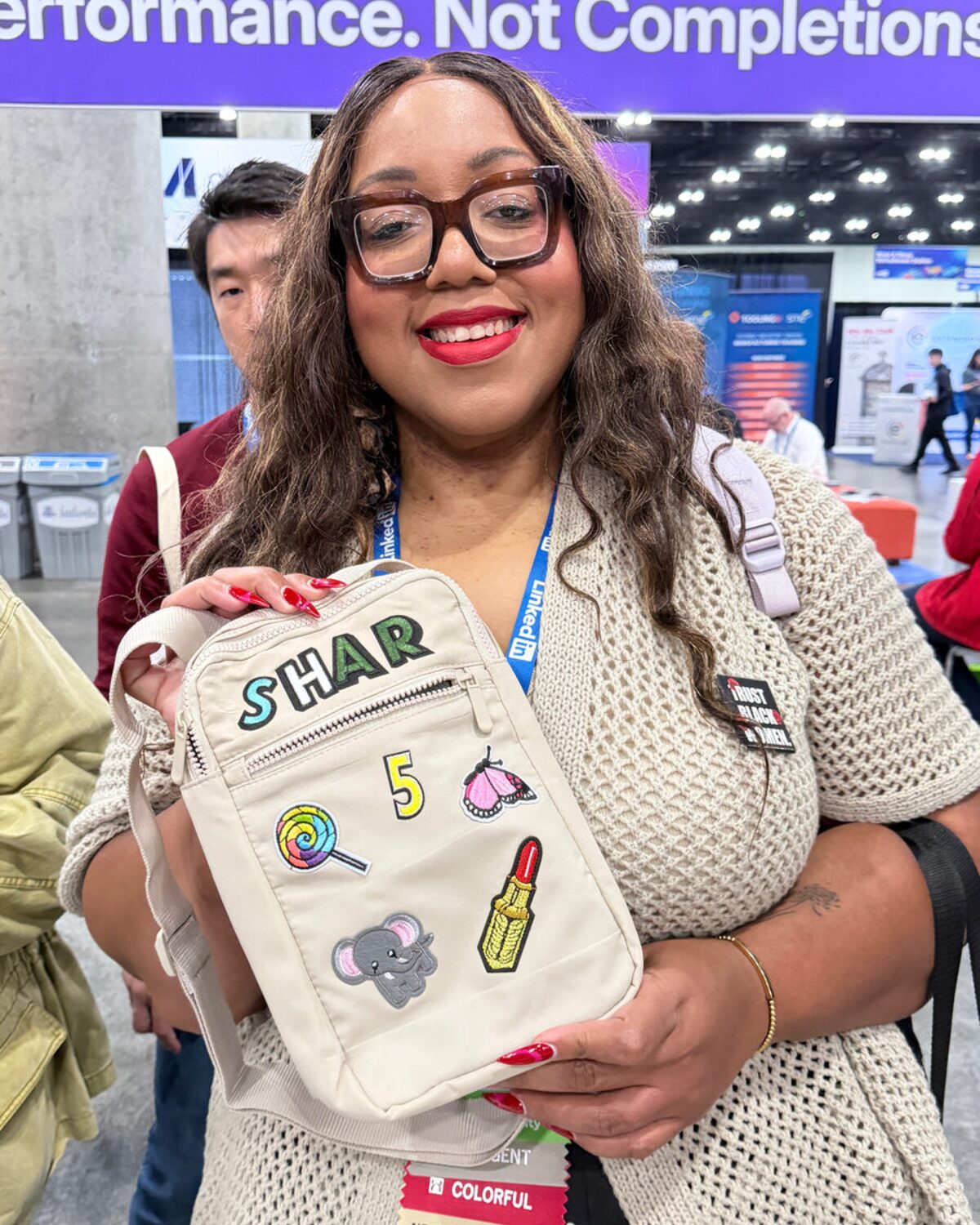 Bridal party guest showing her name in chenille letters across a sling bag